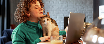 vrouw die thuis werkt met kat op schoot
