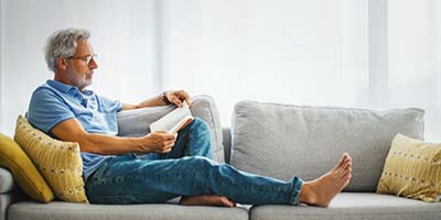 Man leest boek op de bank