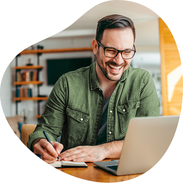 Lachende man met groen shirt achter laptop
