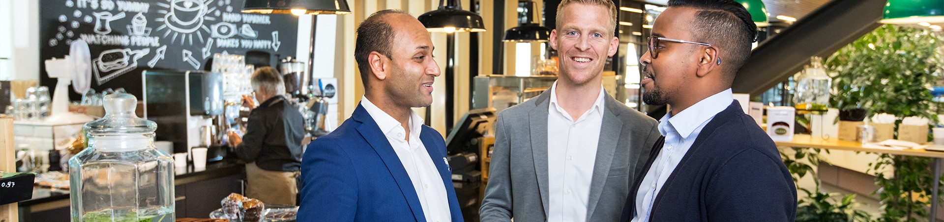 Drie mannelijke collega's in gesprek in bedrijfsrestaurant