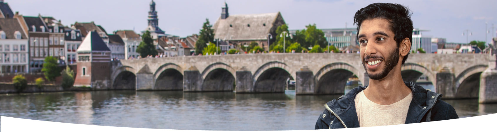 Jongen staat vlakbij rivier de Maas in Maastricht