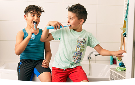 Twee jongens poetsen hun tanden in de badkamer Twee jongens poetsen hun tanden in de badkamer